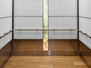 FSRT797 Внутренняя часть лифта Levele-107 с основными панелями из вивихромного хромового стекла с белой прослойкой и отделкой opalex; акцентные панели из нержавеющей стали с льняной отделкой; панели лайтплана из ониксового стекла vivistone abalone в частн